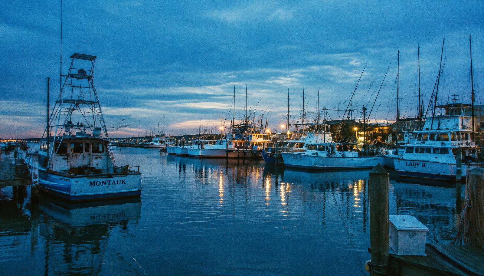 Montauk harbor at blue hour with boats at the docks